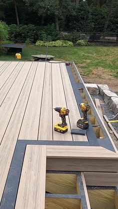 two drillers are sitting on the edge of a deck that's being built