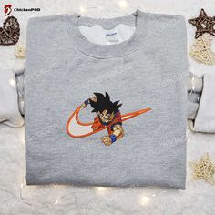 Introducing the ultimate fusion of style and fandom – the Goku x Nike Swoosh Anime Embroidered Tshirt. This Dragon Ball-inspired shirt combines the iconic Nike swoosh with Goku’s power-packed persona, creating a design that’s a must-have for any anime enthusiast. Crafted with meticulous attention to detail, the embroidered artwork brings Goku to life, showcasing his [...] Buu Dbz, Ethereal Realm, Nike Inspired, Goku And Chichi, Best Family Gifts, Hoodie Ideas, Maroon Hoodie, Embroidered Shirts, Balls Shirt