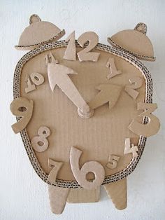 a clock made out of cardboard with numbers on the face and hands, including an owl