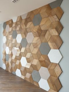 a wooden wall with hexagon tiles on it in an empty room next to a wood floor