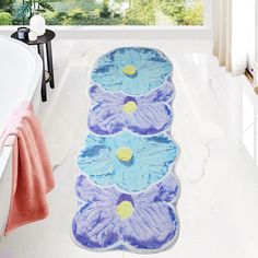 a bath mat with blue and purple flowers on it