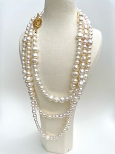 This luxurious necklace features two hundred hand-strung freshwater pearls with a beautiful lustre, meticulously crafted on a 100% silk threader and finished with an exquisite, secure gold OT clasp. A truly unique design allows for multiple ways of wearing the necklace, including three layers, two layers, twisted as a single layer, or any other creative arrangement that suits your personal style. This versatility ensures that you can effortlessly adapt the necklace to complement various outfits Luxury Double Strand Pearl Necklace, Luxury White Double Strand Pearl Necklace, Luxury Double Strand Pearl Necklace For Gift, Luxury Multi-strand Pearl Chain Necklace, Luxury White Single Strand Pearl Necklace, Luxury Long Pearl Necklace For Wedding, White Baroque Pearl Lariat Necklace, Luxury Multi-strand Pearl Necklace For Wedding, Luxury Yellow Gold Baroque Pearl Necklace