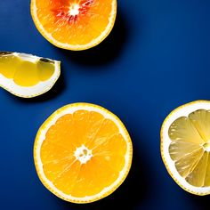 three oranges cut in half on a blue surface