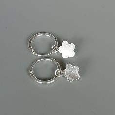 A PAIR of sterling silver hoops. Comes with a detachable cut out flower charm. The charm is multipurpose and can be used with a neck or bracelet chain too. Dimension: Hoop- 12 x 1.5 mm Charm: 7 x 11 mm Drop length- 21 mm These earrings are made of 925 hypoallergenic sterling silver and plastic. Please note this price is for ONE PAIR. All my pieces are sent in a gift box. I can include a personal message from you if needed You are welcome to contact me at... bhavnakwintra1956@gmail.com For more b Gift Huggie Hoop Earrings With Flower Charm, Small Hoop Jewelry With Flower Charm For Everyday, Everyday Small Hoop Jewelry With Flower Charm, Flower Charm Huggie Earrings As Gift, Gift Jewelry Flower Charm Huggie, Handmade Adjustable Huggie Earrings, Nickel Free Silver Huggie, Huggie Jewelry With Flower Charm For Gift, Hoop Earrings With Flower Charm As Gift