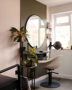 a room with a chair, mirror and potted plant