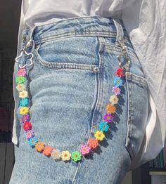 the back of a woman's jean shorts with colorful beads on each side and flowers in the middle