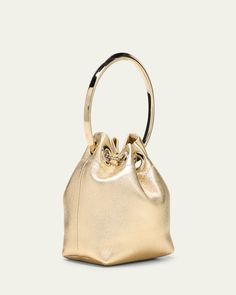 Jimmy Choo "Bon Bon" top handle bag in leather and brass    Metal top handle     Chain drawstring closure     Approx. 4.7"H x 4.7"W x 2.8"D    Made in Italy Chic Gold Bucket Bag For Evening, Handheld Bucket Bag With Gold-tone Hardware For Shopping, Handheld Bucket Bag With Top Carry Handle For Party, Gold Rectangular Bucket Bag For Evening, Modern Gold Bucket Bag For Evening, Formal Gold Bucket Bag With Detachable Strap, Modern Gold Bucket Bag For Formal Occasions, Elegant Gold Bucket Bag For Evening, Gold Handheld Bucket Bag For Evening