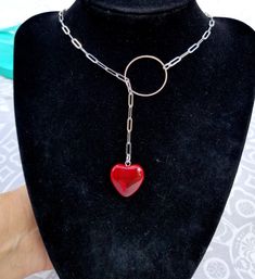 a black mannequin with a red heart shaped pendant on it's neck