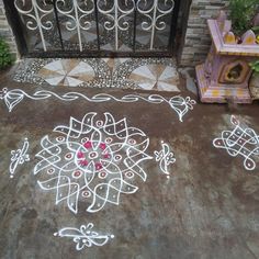 an artistic design on the ground next to a fire place with potted plants in it