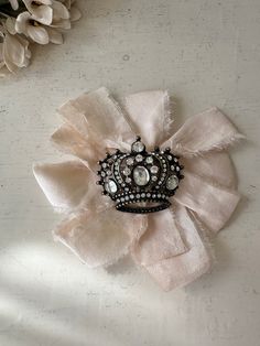 a crown brooch sitting on top of a white table