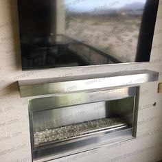 a flat screen tv mounted to the side of a wall next to a fire place