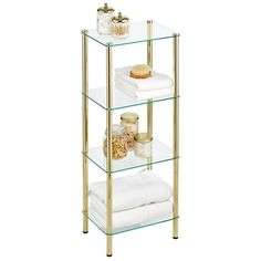 three tiered glass shelf with gold metal legs and white towels on the bottom shelves