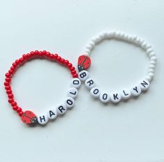 Adjustable Novelty Beaded Bracelet With Custom Name, Novelty Adjustable Beaded Bracelet With Custom Name, White Adjustable Novelty Name Bracelet, Novelty White Stretch Bracelet With Round Beads, White Novelty Stretch Bracelet With Round Beads, Personalized Red Beaded Bracelets With Letter Beads, Red Adjustable Personalized Stretch Bracelet, Adjustable Personalized Red Stretch Bracelet, Red Adjustable Stretch Bracelet, Personalized