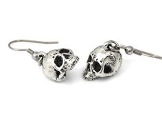 We wanted these skulls to be a little more realistic and spooky than our other human skull earrings and we think that we pulled it off nicely! The design was carved by hand in wax and then molded and cast in metal.The skull charms are cast in Lead Free Pewter and weighs a bit under 5 grams each. They are about 13 mm long (just over half an inch) and dangle from Stainless Steel earring hooks. They are oxidized to fill in the details and then polished.For more of our skull earrings please look her Gothic Skull Shaped Pierced Earrings, Gothic Skull Earrings For Halloween, Gothic Skull Earrings, Adjustable Gothic Skull Earrings, Silver Skull Earrings With Skull Print, Punk Skull Print Earrings Gift, Punk Skull Print Earrings For Gift, Punk Style Skull Print Earrings As Gift, Nickel-free Skull Earrings In Punk Style