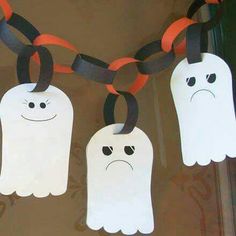 three ghost shaped paper tags hanging from a chain