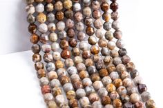 several strands of multicolored beads on a white surface with one strand missing from the bea