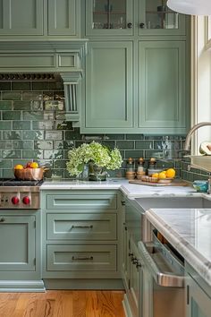 a kitchen filled with lots of green cabinets and counter top space next to a sink