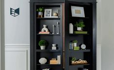 a black bookcase with books and pictures on it