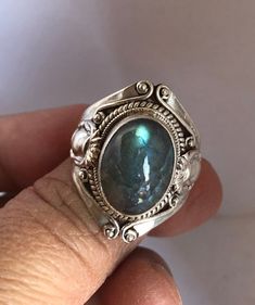 A labradorite silver ring is here for you. It is handmade in Nepal and wonderful color of labradorite, it has blue-green shine and looks beautiful. Dainty ring and natural labradorite and unique ring. Beautifully made. Size of the ring 7 US Silver Labradorite Crystal Ring With Gemstone, Unique Silver Labradorite Ring, Vintage Labradorite Gemstone Rings, Silver Crystal Ring With Labradorite Stones, Silver Labradorite Ring Stamped 925, Handmade Silver Labradorite Crystal Ring, Handmade Silver Crystal Ring With Labradorite, Round Labradorite Moonstone Ring Stamped 925, Unique Labradorite Ring With Large Stone