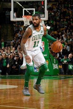 a basketball player dribbling the ball in front of an arena full of people