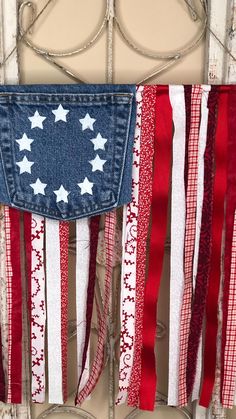 an american flag made out of old jeans hanging on a door with ribbons attached to it