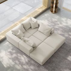 a large white couch sitting on top of a carpeted floor next to a window