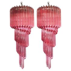 pair of pink glass chandeliers with long fringes on the ends and sides