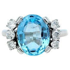 Ring Size: 6.5 This elegant ring features a captivating oval blue topaz as its centerpiece and is set in lustrous 14 karat white gold. Flanking the topaz on each side are 3 shimmering round diamonds, adding a touch of brilliance and sophistication to the design. The contrast between the icy brilliance of the diamonds and the soothing blue of the topaz creates a harmonious balance, making this ring a versatile accessory suitable for both casual and formal occasions. Whether worn for a formal occa Aquamarine Cocktail Ring, Contemporary Engagement Rings, Tanzanite Diamond Ring, Platinum Diamond Rings, Vs Diamond, Platinum Ring, Pear Shaped Diamond, Elegant Ring, Brilliant Diamond