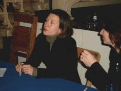 two women sitting at a table talking to each other