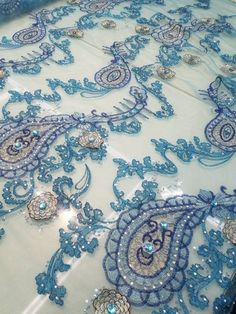 an elaborate blue and white table cloth with beads