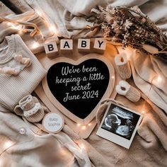 a baby announcement is displayed on top of a blanket with other items and lights around it