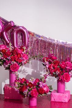 pink vases filled with flowers and balloons