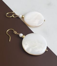 Solazur earrings "Shella" --- Beautiful. Different. Original design. These Solazur summer earrings will add a pop of style and a breeze of glamour to your outfit. Seashells are the best summer and beach reminder, and wearing them will make you feel you're on vacation every day :-)  Modern, romantic, chic and joyful are few words to describe them. I love how beautiful the shell texture glows and reflects from different angles.  They will match beautiful with either a dress or jeans; will make a nice gift idea for any occasion. Or offer them to yourself, no reason needed :-) Each pair is unique - made with two round flat natural shell disc, glass accent beads and brass. ♡ They can be paired with a necklace - sold separately, see link below: https://solazurjewelry.etsy.com/ca/listing/13080686 Brass Earrings Handmade, Shell Texture, Earrings Handmade Beaded, Beach Wedding Jewelry, Earrings Beach, Seashell Earrings, Summer Earrings, Disc Earrings, Summer Earring