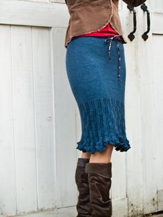 a woman in boots and a skirt holding an umbrella