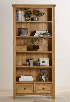 an oak bookcase with drawers and plants