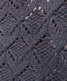 a crocheted blanket is shown with blue dots on the edges and an intricate design