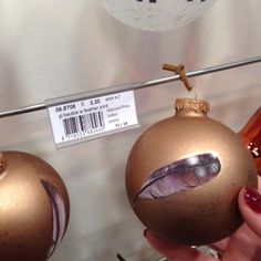 two christmas ornaments are on display with price tags hanging from the top and bottom of each ornament