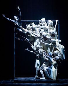 a group of people standing on top of each other in front of a black background