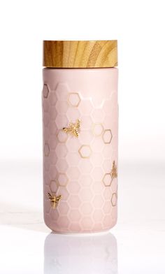 a pink jar with bees and honeycombs on it