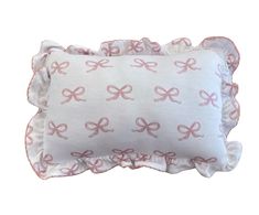 a white pillow with pink bows on it