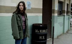 a woman standing next to a trash can