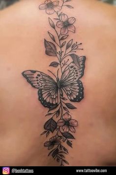 a woman's back with a butterfly and flowers on it