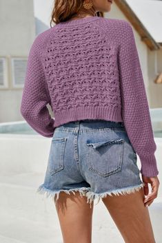 a woman wearing shorts and a purple sweater