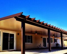 a covered patio with sliding glass doors and ceiling fan on the side of the house