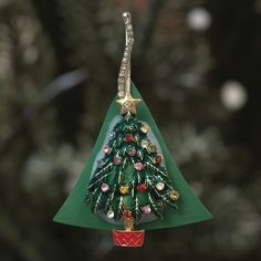 a green christmas tree ornament hanging from a string