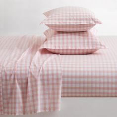 pink gingham checkered sheets and pillow cases on a white bed with two pillows