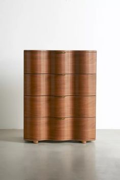 a large wooden dresser sitting on top of a cement floor next to a white wall