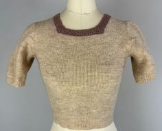 "This darling 1950's knit is easy to match and feels cozy on your back! The main body is a wool of mottled ivory and oatmeal with a square neckline crocheted in taupe with a lacey look. Ribbed cuffs and waistband. This sweater is in great vintage condition, with a couple tiny period mends but no holes, stains, or odors to note.  Measurements taken flat and doubled where appropriate: (shown fit comfortably on a 32/25 mannequin) Bust:  32\" - 35\" comfortably Shoulder: 13\" Sleeve: 8.5\" Waist: 22 Fitted Beige Crew Neck Sweater, Beige Fitted Crew Neck Sweater, Fitted Knitted Beige Sweater, Fitted Beige Knitted Sweater, Vintage Knitted Beige Tops, Fitted Soft Knit Beige Sweater, Fitted Beige Soft Knit Sweater, Vintage Beige Knitted Tops, Vintage Cream Knit Tops