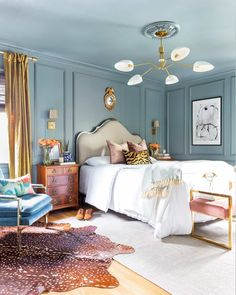 a bedroom with blue walls and white bedding, rugs on wooden flooring