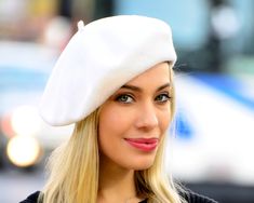 a woman with blonde hair wearing a white hat